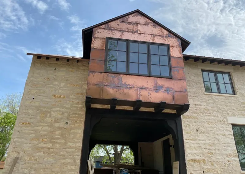 Copper metal panel facade on a stone building for Skylight Installation in Laplace